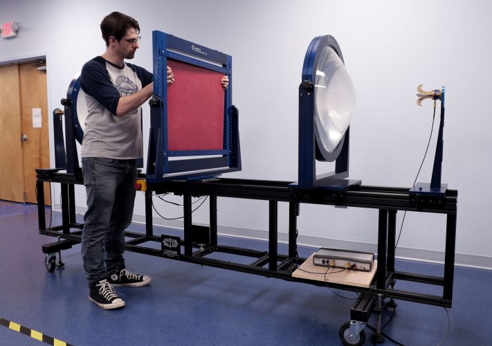 Man sets up microwave focused beam measurement system.
